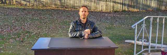 Tom Ray sitting at a desk outside